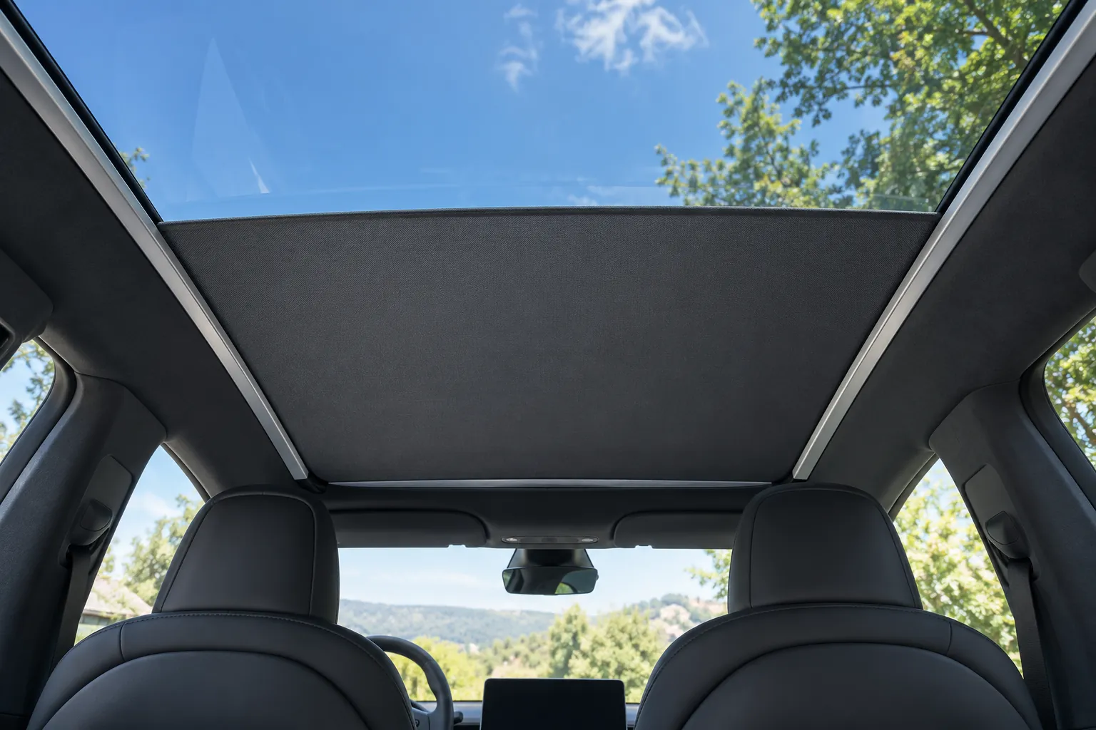 Tesla Model Y 電動布質遮陽簾白天半開情境示意